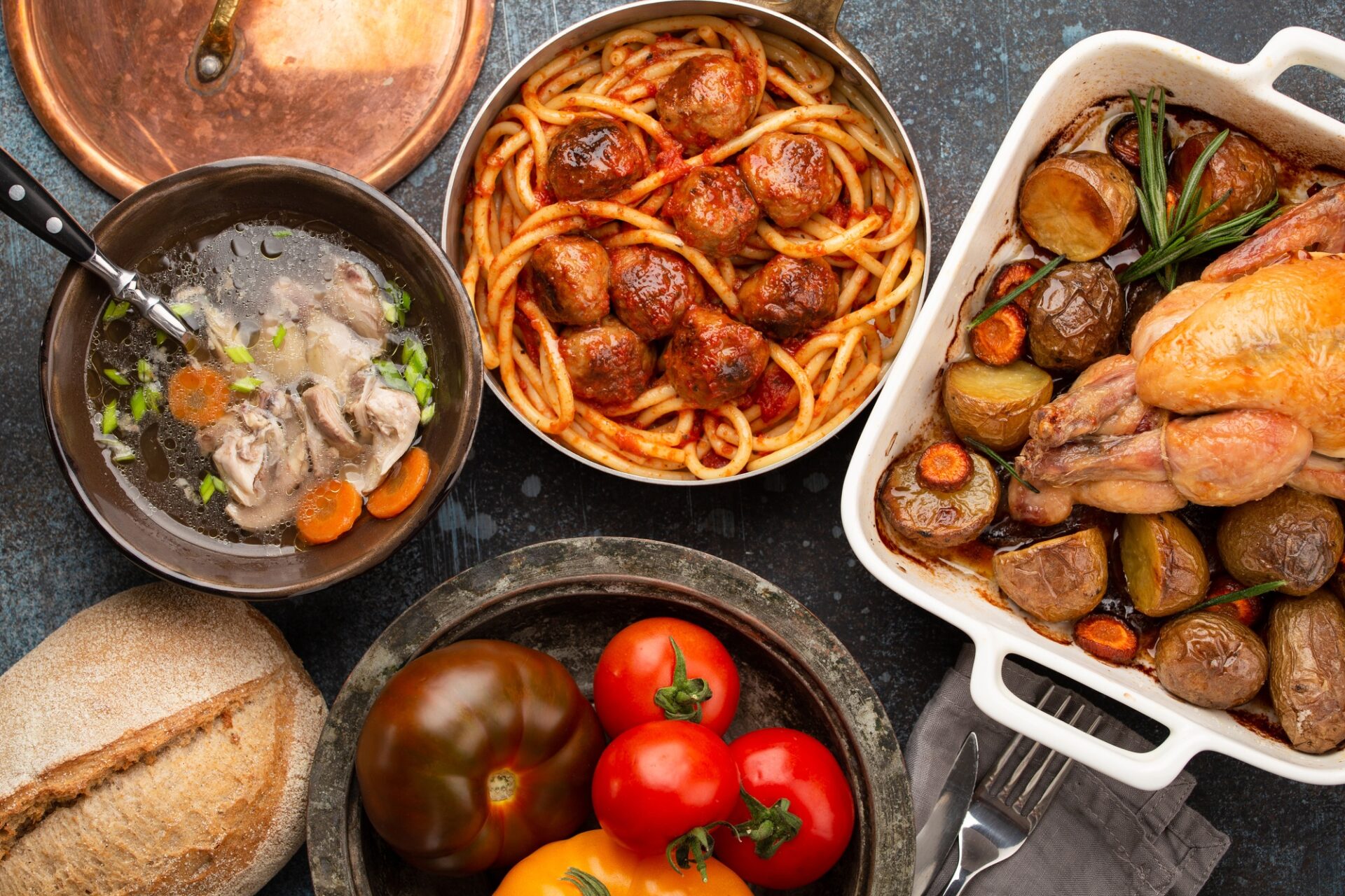 Table à manger avec plats traditionnels de savoureux maison: soupe de poulet, boulettes de viande avec spaghettis, poulet rôti avec pommes de terre.
